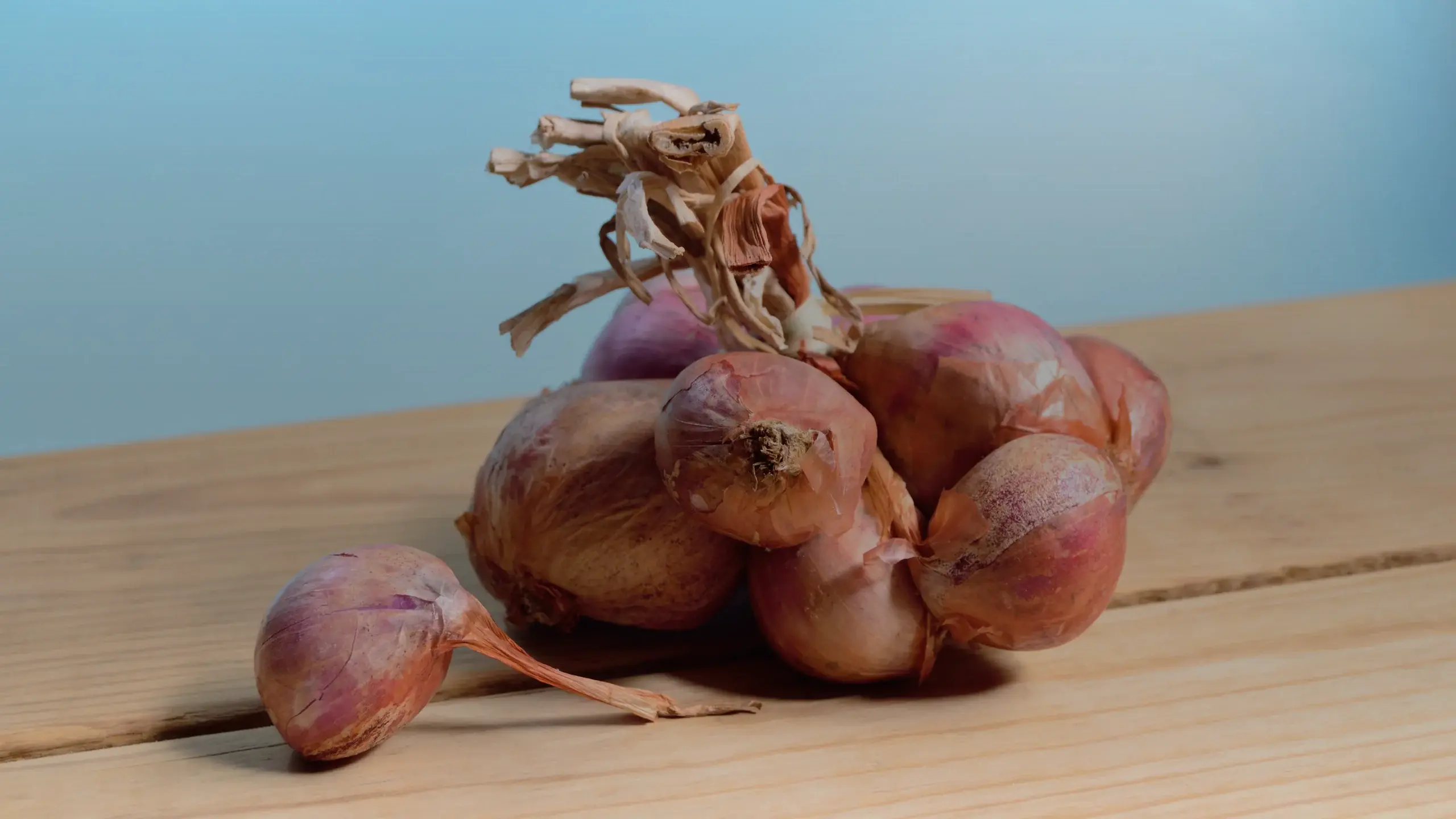 Échalotes roses sur une planche en bois