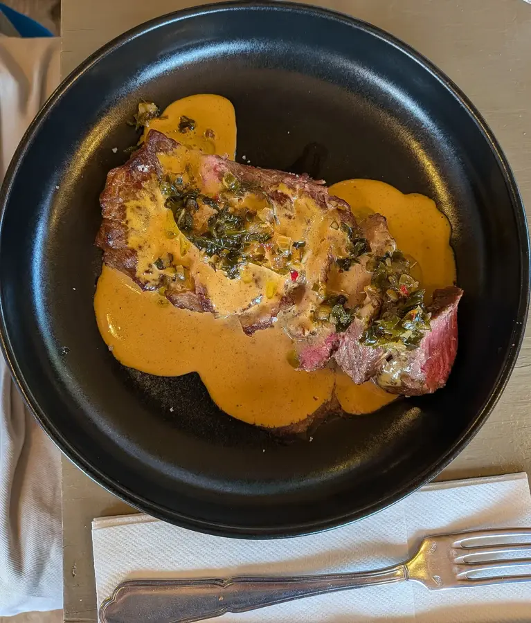 Bavette nappée d'une sauce au poivre crémeuse dans une assiette noire