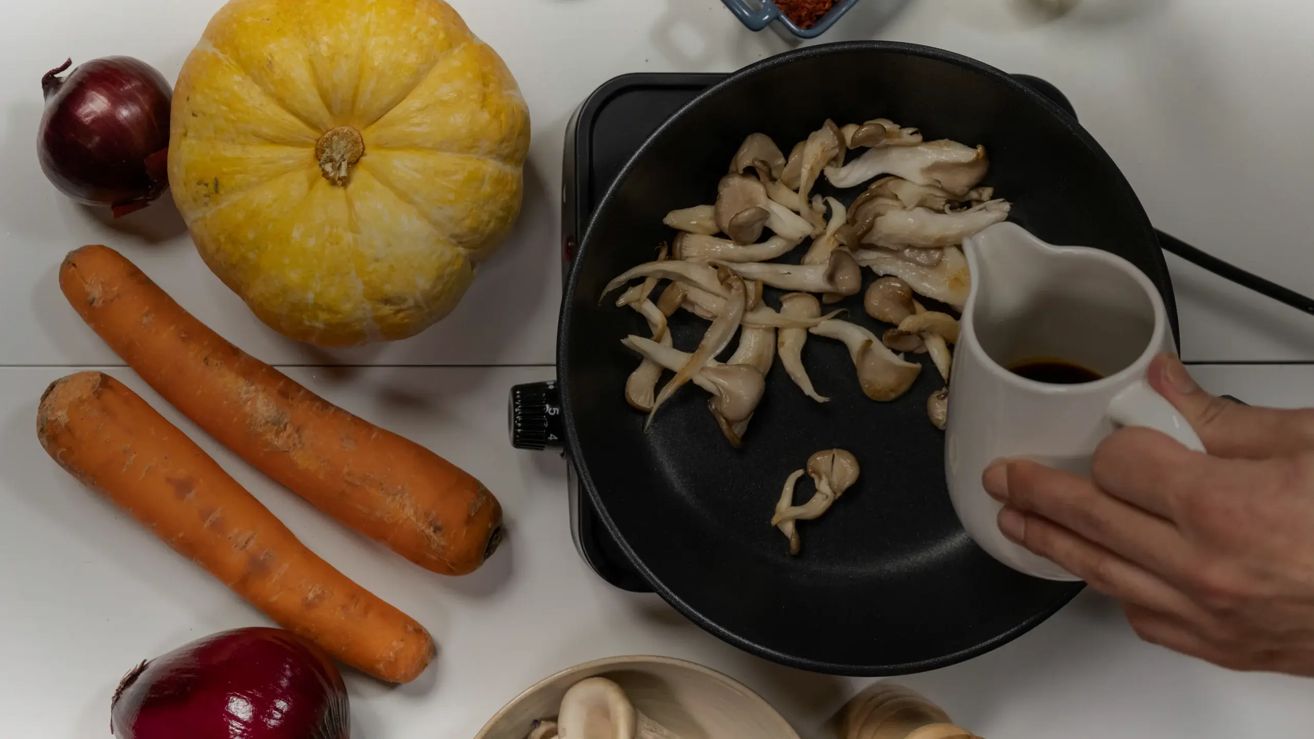 Champignons sautés à la poêle avec un pichet de sauce